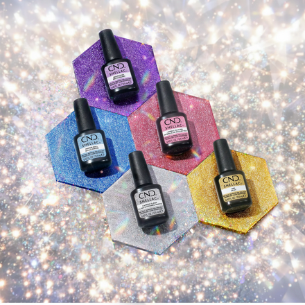 CND Shellac Glittercore collection — five glitter gel polish bottles in purple, blue, pink, silver, and gold on a sparkling silver background