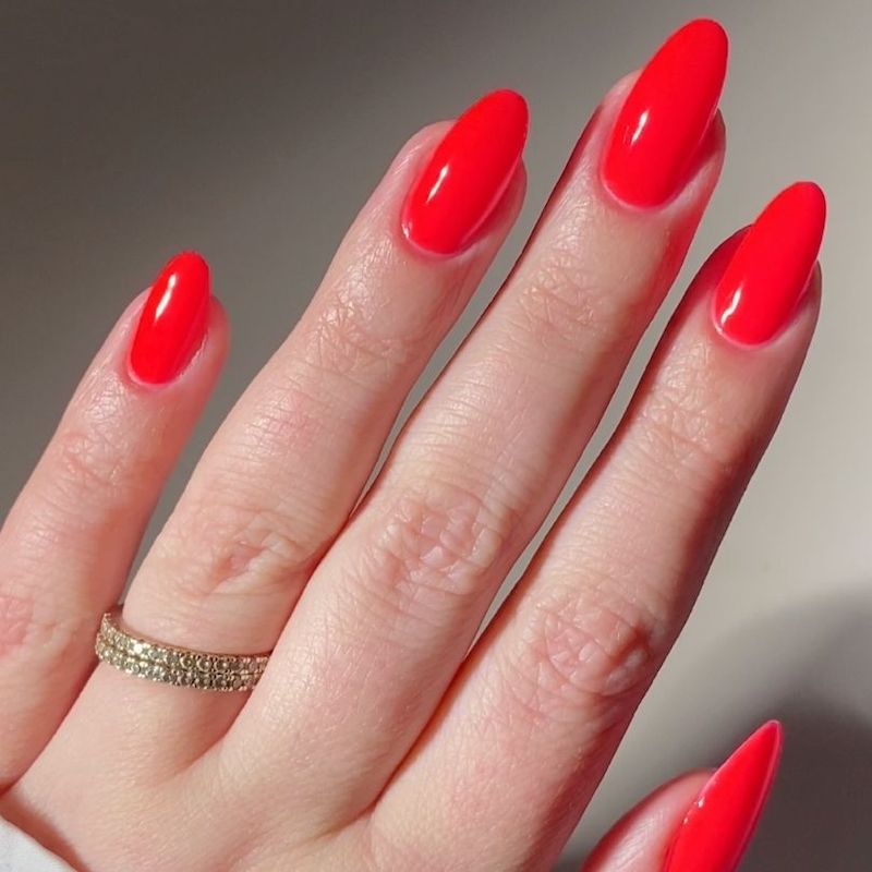 Left hand featuring the DND Jellyfish Candy color in bright red