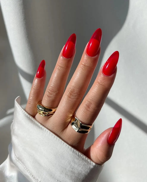 Closeup picture of a hand with a red jelly manicure in natural lighting